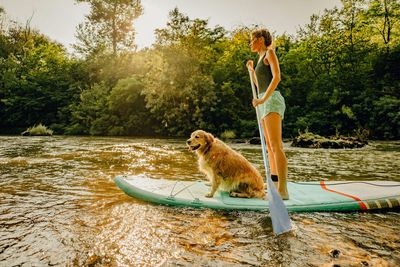 Frau und Hund auf einem SUP Board am Fluss